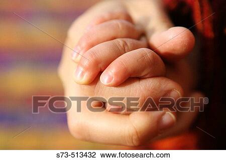 Stock Image - Mother and baby's hands. Fotosearch