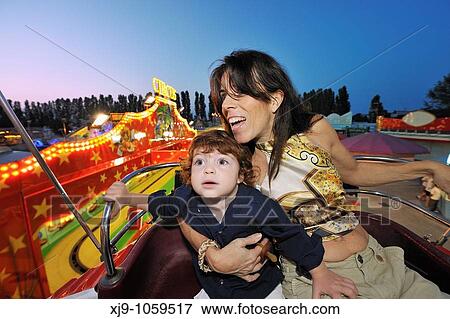 Mother and child on rides and ferris wheel View Large Photo Image Stock Photo - Mother and child on rides and ferris wheel. Fotosearch