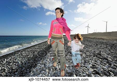 Mother and child strolling on the beach with the wind park at their View Large Photo Image Stock Photo - Mother and child strolling on the beach with the wind park at their. Fotosearch