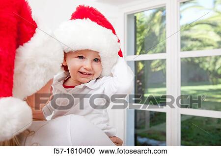 Stock Image - Mother and child wearing Santa hats. Fotosearch