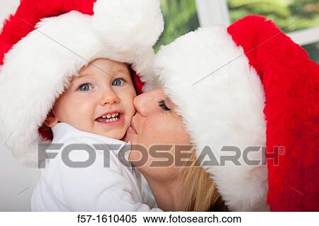 Stock Photography - Mother and child wearing Santa hats. Fotosearch