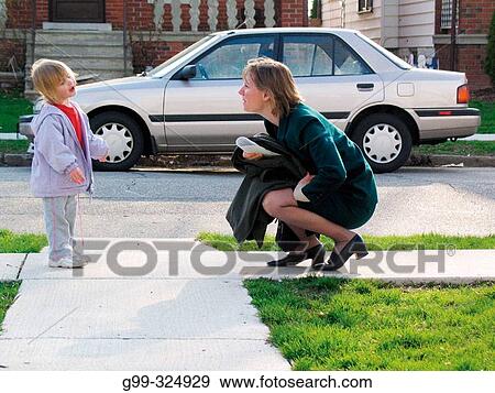 Stock Photo - Mother and daughter as mom returns home from work in Windsor. Ontario, Canada. Fotosearch