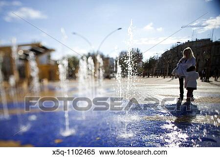 Mother and daughter by a fountain, Alameda de Hercules square, Seville, Spain Tilted lens used for shallower depth of field View Large Photo Image Stock Photography - Mother and daughter by a fountain, Alameda de Hercules square, Seville, Spain Tilted lens used for shallower depth of field. Fotosearch