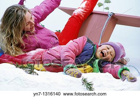 mother and daughter enjoying crashing their sled in the snow View Large Photo Image Stock Image - mother and daughter enjoying crashing their sled in the snow. Fotosearch