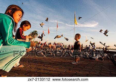 Mother and daughter feeding pigeons near the Tonle Sap. Phnom Penh. Khmer people are the predominant ethnic group in Cambodia View Large Photo Image Stock Image - Mother and daughter feeding pigeons near the Tonle Sap. Phnom Penh. Khmer people are the predominant ethnic group in Cambodia. Fotosearch