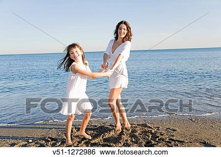 Mother and daughter having fun at the beach View Large Photo Image Stock Photograph - Mother and daughter having fun at the beach. Fotosearch