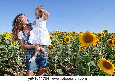 Picture - mother and daughter in a field of sunflowers. Fotosearch