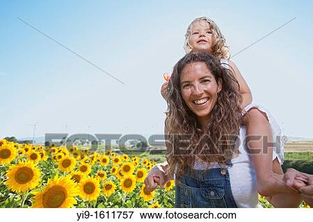 Stock Photo - mother and daughter in a field of sunflowers. Fotosearch