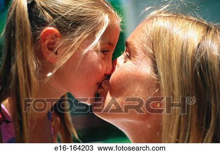 Stock Image - Mother and daughter kissing. Fotosearch