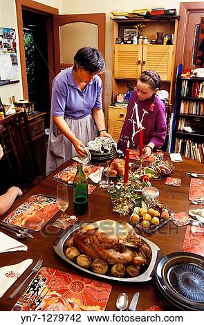 Stock Image - mother and daughter laying out Sunday dinner. Fotosearch