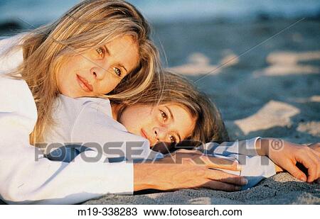 mother and daughter lying on the sand View Large Photo Image Stock Image - mother and daughter lying on the sand. Fotosearch