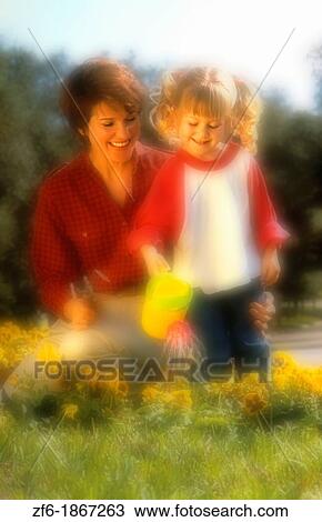 Mother and daughter outside gardening at home View Large Photo Image Stock Image - Mother and daughter outside gardening at home. Fotosearch