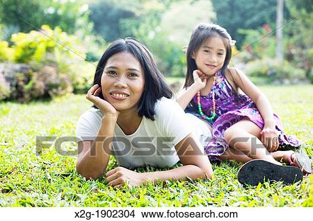 Mother and daughter playing in a garden View Large Photo Image Picture - Mother and daughter playing in a garden. Fotosearch
