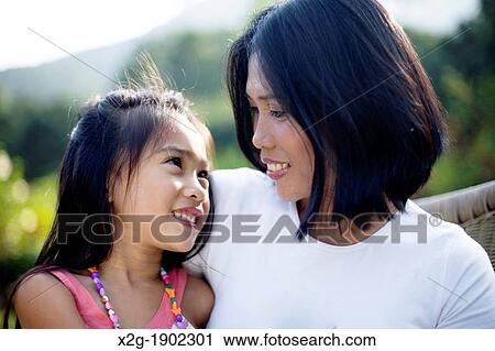 Mother and daughter playing in a garden View Large Photo Image Stock Image - Mother and daughter playing in a garden. Fotosearch