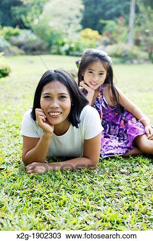 Mother and daughter playing in a garden View Large Photo Image Stock Image - Mother and daughter playing in a garden. Fotosearch