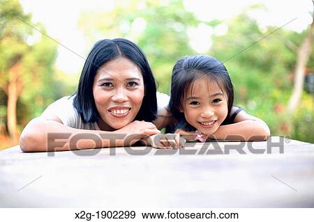 Mother and daughter playing in a garden View Large Photo Image Stock Photo - Mother and daughter playing in a garden. Fotosearch