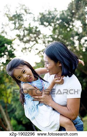 Mother and daughter playing in a garden View Large Photo Image Stock Photograph - Mother and daughter playing in a garden. Fotosearch