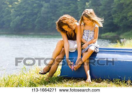 Mother and daughter, putting-on flip-flops View Large Photo Image Stock Image - Mother and daughter, putting-on flip-flops. Fotosearch