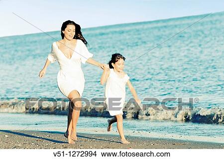 Mother and daughter running at the beach View Large Photo Image Picture - Mother and daughter running at the beach. Fotosearch