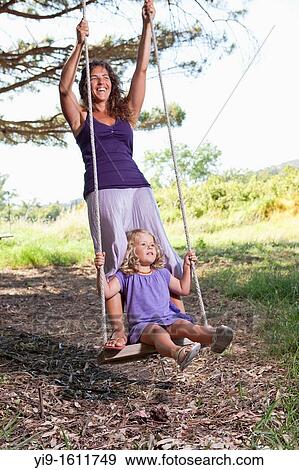 Stock Photo - mother and daughter swinging. Fotosearch