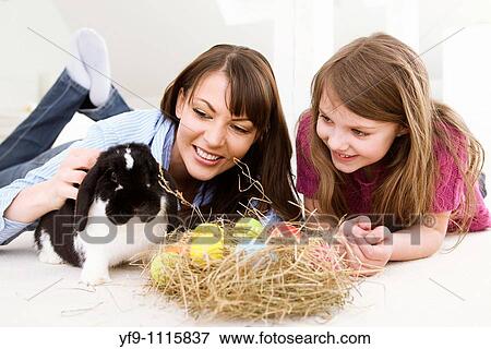 Mother and daughter with Easter Eggs and rabbit. View Large Photo Image Stock Photo - Mother and daughter with Easter Eggs and rabbit.. Fotosearch