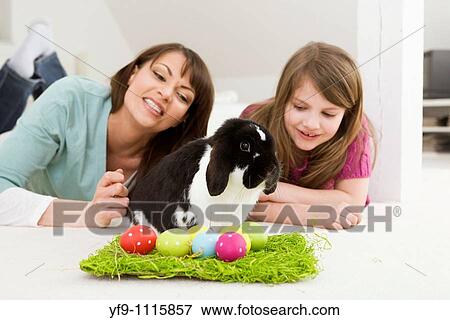 Mother and daughter with Easter Eggs and rabbit. View Large Photo Image Stock Photo - Mother and daughter with Easter Eggs and rabbit.. Fotosearch