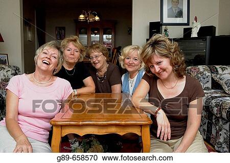 Stock Image - Mother and daughters gathered around the table.. Fotosearch