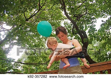 Stock Image - Mother and her son at his one-year-old birthday party. Fotosearch