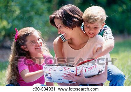 Stock Image - Mother and kids reading.. Fotosearch