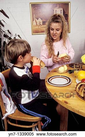 Stock Photography - Mother and son discussing their meal at the dinner table. Fotosearch