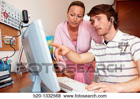 Mother and son looking at PC in room View Large Photo Image Stock Photo - Mother and son looking at PC in room. Fotosearch