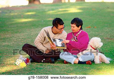 Mother and son looking photo album View Large Photo Image Stock Photo - Mother and son looking photo album. Fotosearch