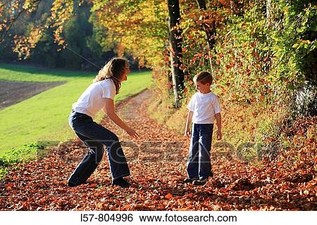 Mother and son playing with leaves in fall, having fun, autumn foliage covering path in forest, autumn, fall, Zuerich, Switzerland View Large Photo Image Stock Photograph - Mother and son playing with leaves in fall, having fun, autumn foliage covering path in forest, autumn, fall, Zuerich, Switzerland. Fotosearch