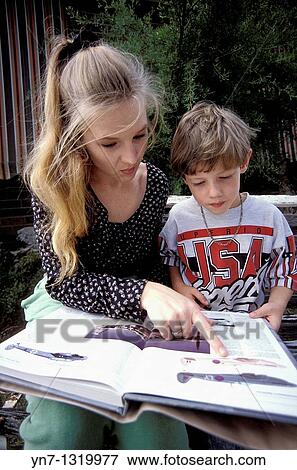 Mother and son sharing a book outdoors View Large Photo Image Stock Photo - Mother and son sharing a book outdoors. Fotosearch