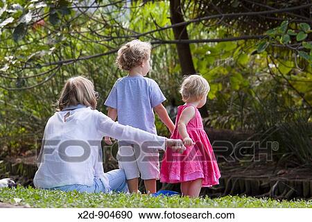Mother and two children enjoying the park View Large Photo Image Stock Image - Mother and two children enjoying the park. Fotosearch