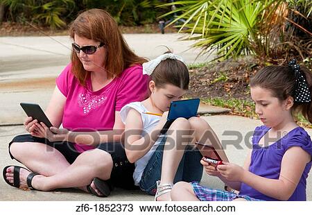 Mother and two daughters aged 6 and 8 playing and learning in front of home relaxing with games and computers learning View Large Photo Image Stock Image - Mother and two daughters aged 6 and 8 playing and learning in front of home relaxing with games and computers learning. Fotosearch