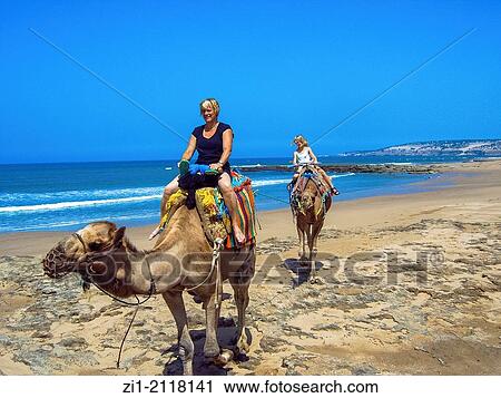 Stock Image - mother and two daughters go for camel ride at Sidi Kaouki beach, Maroc. Fotosearch