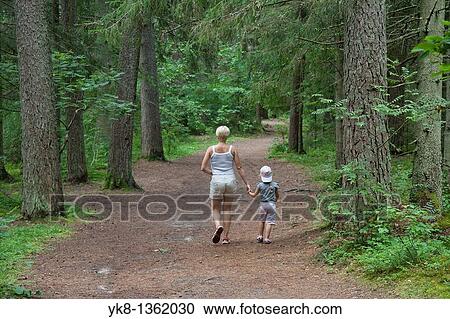 Stock Image - Mother and Young Girl Walking in Forest Holding Hands, P? lva County, Estonia. Fotosearch
