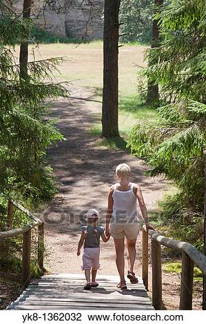 Mother and Young Girl Walking on Boardwalk in Forest Holding Hands, P? lva County, Estonia View Large Photo Image Stock Image - Mother and Young Girl Walking on Boardwalk in Forest Holding Hands, P? lva County, Estonia. Fotosearch