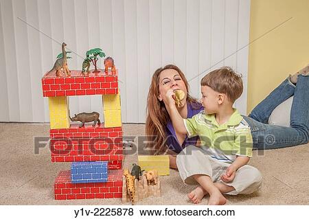 Stock Photo - Mother and young son playing with his toys.. Fotosearch