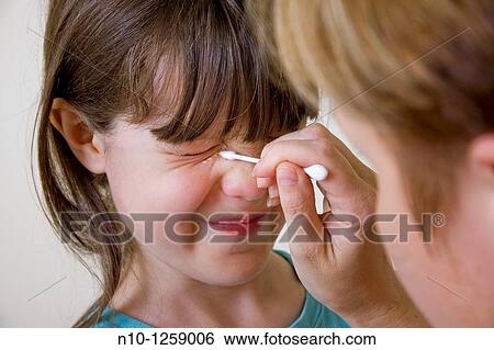 Mother applying makeup to her daughter's face View Large Photo Image Stock Photograph - Mother applying makeup to her daughter's face. Fotosearch