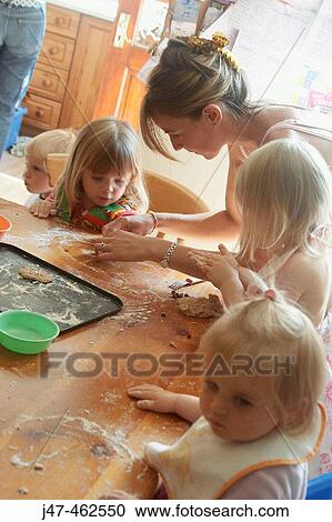 Mother baking with a group of children View Large Photo Image Stock Image - Mother baking with a group of children. Fotosearch