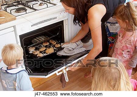 Mother baking with a group of children, putting the bread in the oven. View Large Photo Image Stock Image - Mother baking with a group of children, putting the bread in the oven.. Fotosearch
