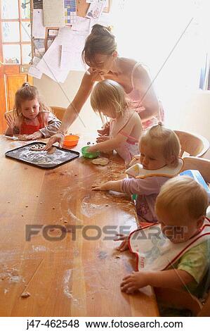 Mother baking with a group of children View Large Photo Image Stock Photo - Mother baking with a group of children. Fotosearch