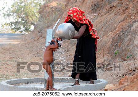 Mother bathing child on a handpump on roadside, India. View Large Photo Image Stock Image - Mother bathing child on a handpump on roadside, India.. Fotosearch
