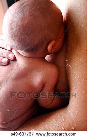 Stock Photo - Mother bathing her newborn baby. Fotosearch