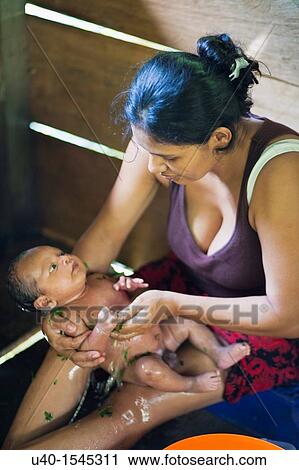 Stock Image - Mother bathing infant. Fotosearch