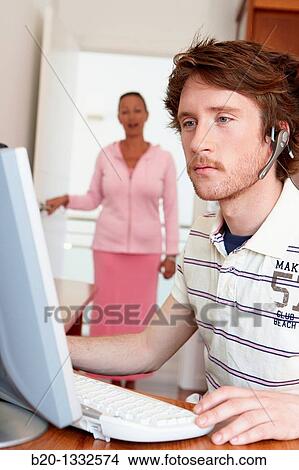 Mother calling son who is looking at computer in his room View Large Photo Image Picture - Mother calling son who is looking at computer in his room. Fotosearch