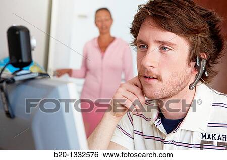 Stock Photograph - Mother calling son who is looking at computer in his room. Fotosearch