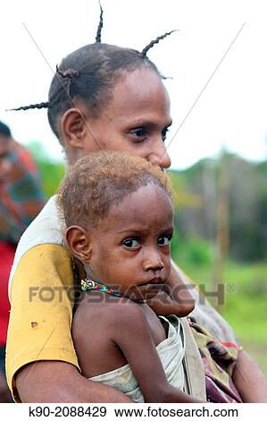 Mother carrying her kid, Papua, Indonesia, Southeast Asia. View Large Photo Image Stock Photo - Mother carrying her kid, Papua, Indonesia, Southeast Asia.. Fotosearch